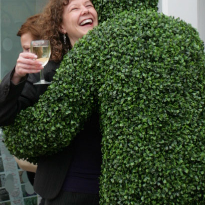 A Hedge Man giving a hug at a corporate reception in London